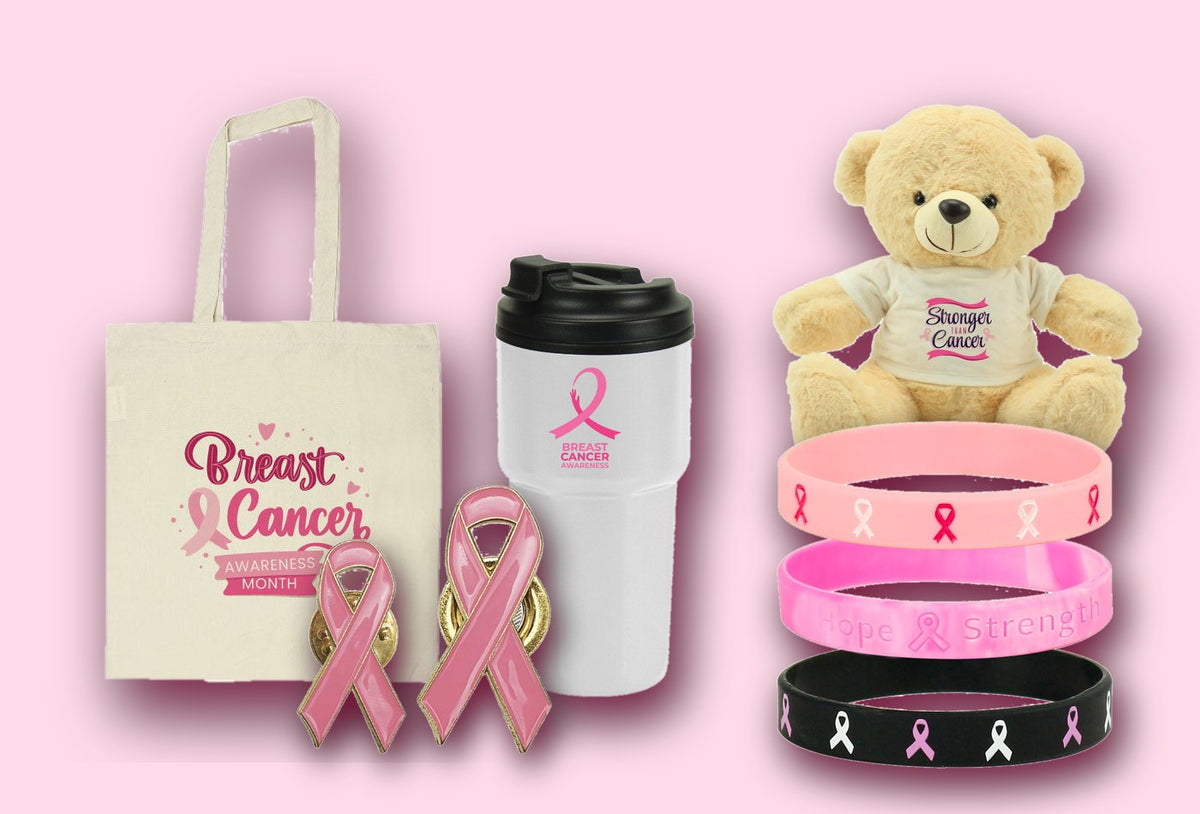 Pink ribbon awareness gifts from MaxPrint Dubai — cotton tote bag, travel mug, enamel ribbon badges, silicone wristbands and a teddy bear