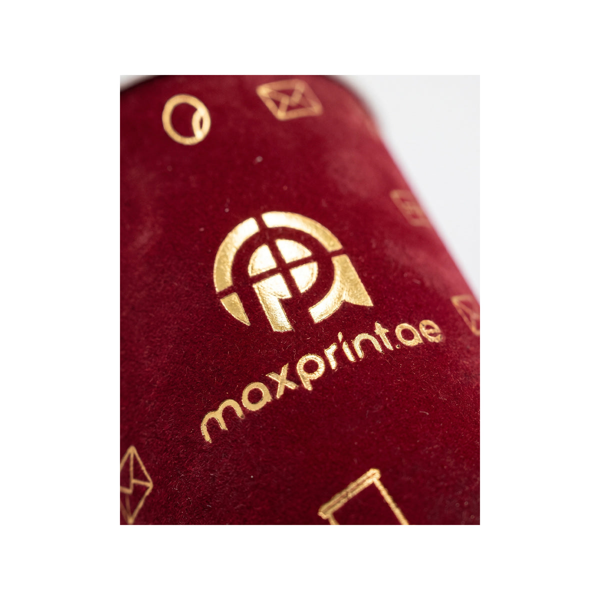 Close-up of gold foil stamped on maroon velvet paper cup — MaxPrint Dubai